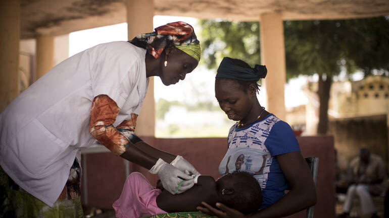 Frau mit Baby und Gesundheitshelferin Frau mit Baby und Gesundheitshelferin