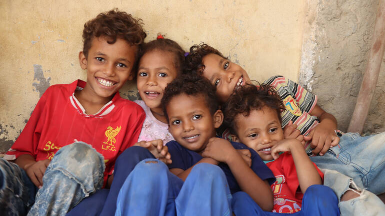 Fünf Kinder schauen lachend in die Kamera Fünf Kinder schauen lachend in die Kamera