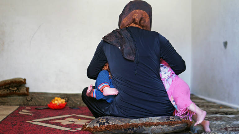 Dana füttert ihre Zwillinge Nagham (11 Monate) und Akram (11 Monate) gleichzeitig in ihrem Haus in der Sammelunterkunft im Südlibanon im Mai 2022. Dana füttert ihre Zwillinge Nagham (11 Monate) und Akram (11 Monate) gleichzeitig in ihrem Haus in der Sammelunterkunft im Südlibanon im Mai 2022.