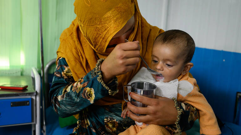 Eine Mutter füttert ihr mangelernährtes Kleinkind mit therapeutischer Milch in der Klinik in Kabul. Eine Mutter füttert ihr mangelernährtes Kleinkind mit therapeutischer Milch in der Klinik in Kabul.