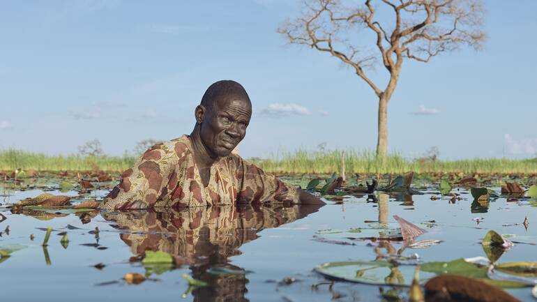 Changjaik Wal geht durch das Wasser in der Nähe seines schwimmenden Hauses in Tuonguan, einem Dorf außerhalb von Old Fangak im Südsudan.