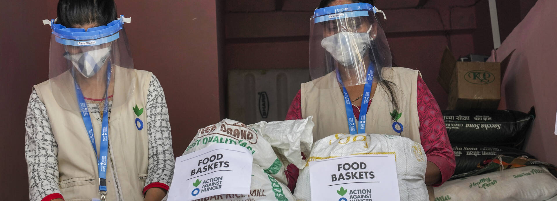 Zwei Mitarbeiterinnen verteilen Lebensmittel Zwei Mitarbeiterinnen verteilen Lebensmittel