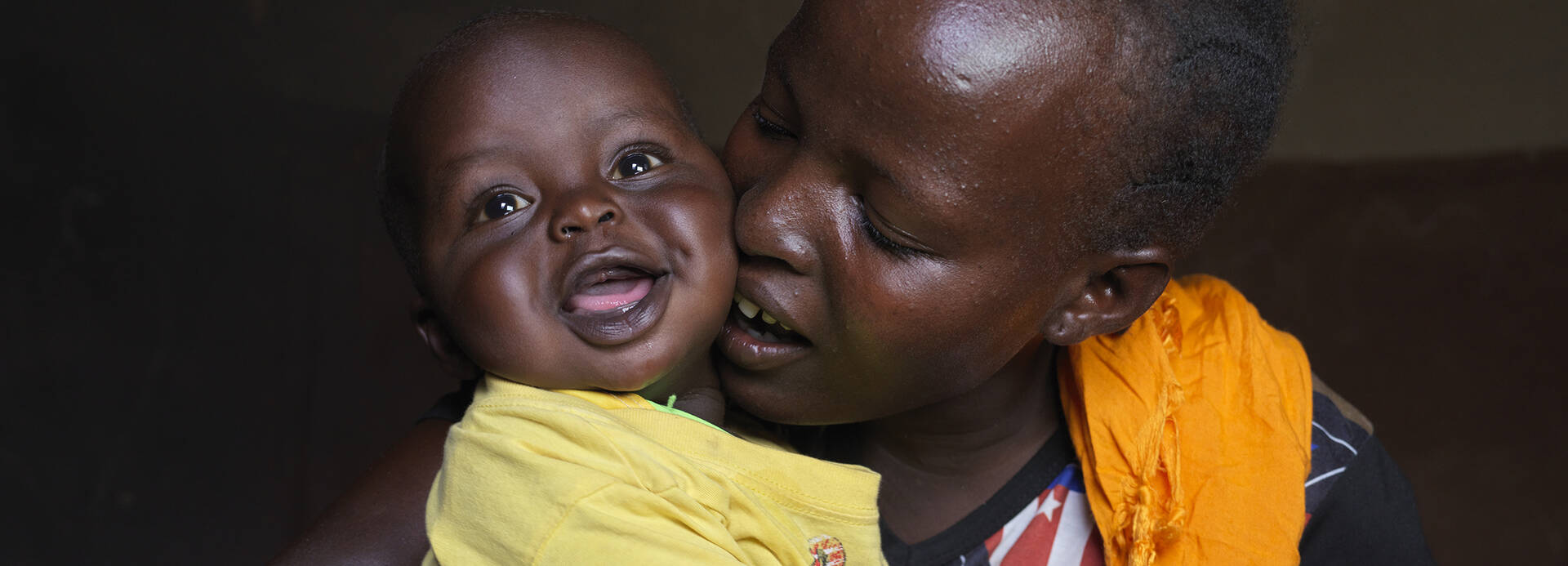 In vielen Ländern, unter anderem in Kenia, schulen wir Mütter in gesunder Ernährung, damit sie ihre Kinder problemlos stillen können. Eine Mutter aus Kenia drückt ihr lachendes Kind liebevoll an sich
