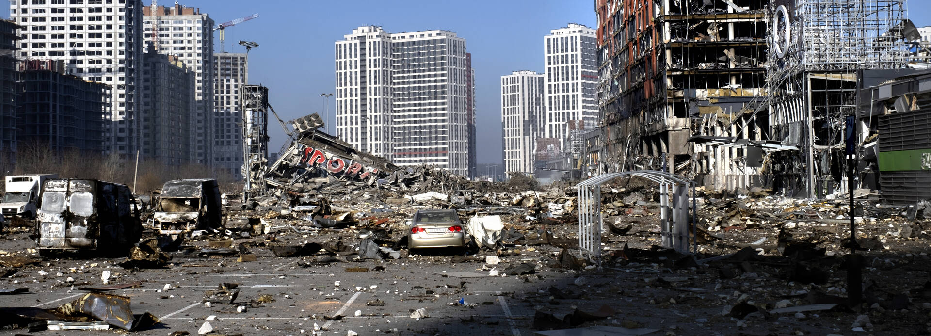Eine Shopping Mall in Kiyv steht nicht mehr: Bomben haben sie im März 2022 getroffen und ein Bild der Verwüstung zurückgelassen. Ruinen und ein Parkplatz voller Geröll, im Hintergrund Hochhäuser – hier stand bis März 2022 eine Shopping Mall in Kiyv.