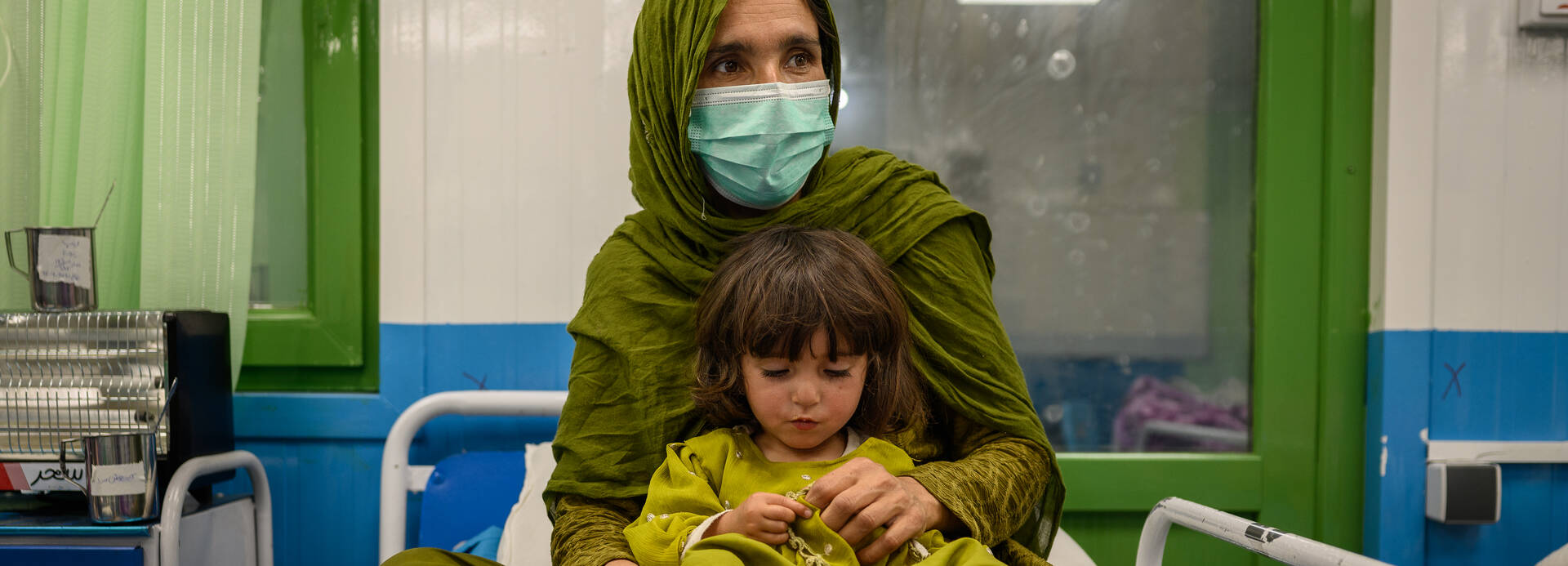 Wird ein Kind in unserer Ernährungsstation in der Klinik in Kabul behandelt, darf die Mutter dabei bleiben. Eine afghanische Mutter sitzt zusammen mit ihrer Tochter auf einem Bett in unserer Ernährungsstation in einer Klinik in Kabul.