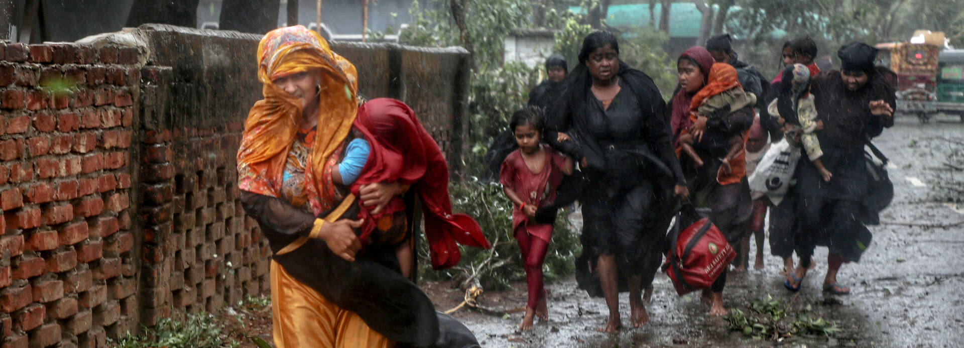 Frauen mit Kindern flüchten durch den Regen vor Zyklon Mocha in Bangladesch Frauen mit Kindern flüchten durch den Regen vor Zyklon Mocha in Bangladesch