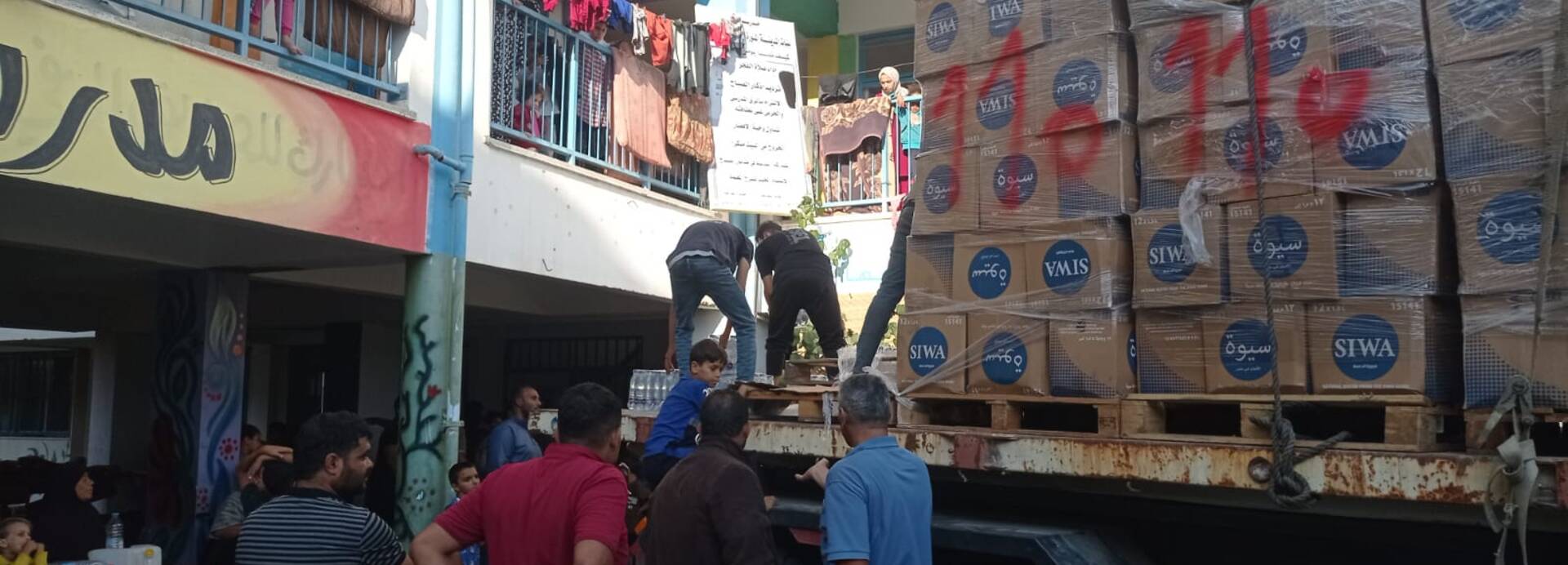 Helfer von Aktion gegen den Hunger verteilen Wasser in Gaza.