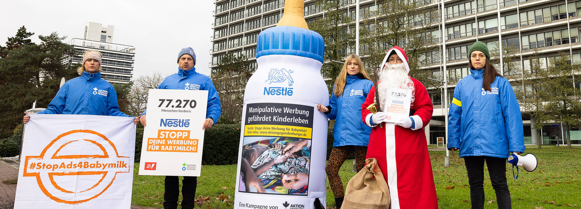 Das Team von Aktion gegen den Hunger und der Nikolaus stehen zusammen mit einer aufblasbaren Babymilchflasche vor der Nestlé-Zentrale in Frankfurt am Main. Das Team von Aktion gegen den Hunger und der Nikolaus stehen zusammen mit einer aufblasbaren Babymilchflasche vor der Nestlé-Zentrale in Frankfurt am Main.