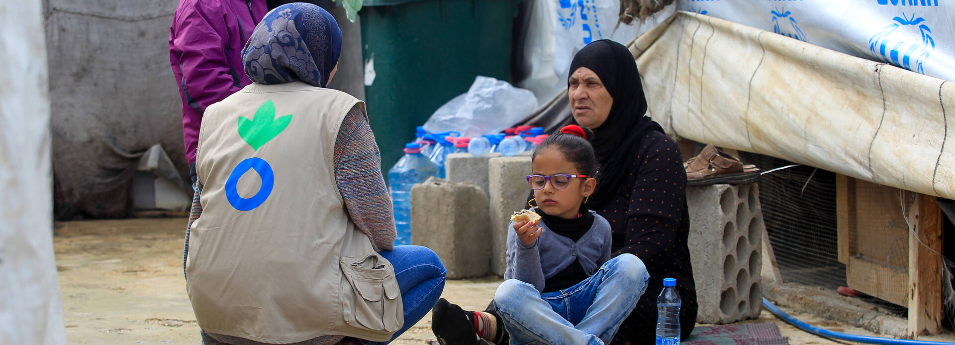 Ein Mitarbeiterin von Aktion gegen den Hunger spricht mit einer Geflüchtetenfamilie im Libanon.
