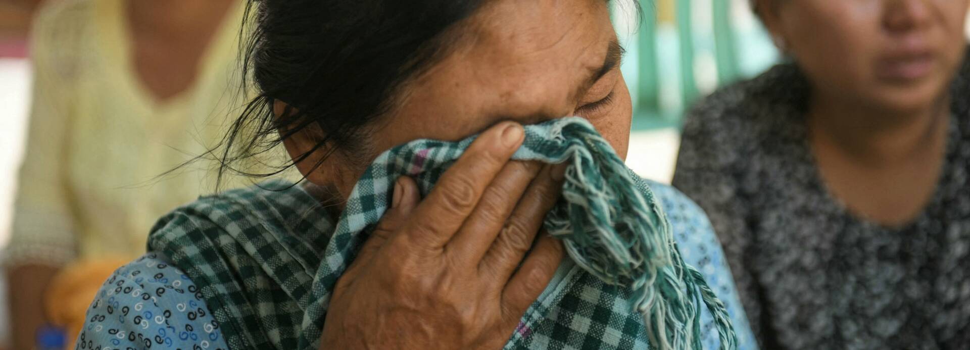 Eine Frau wartet auf Ergebnisse einer Suchaktion nach Verschütteten infolge eines Erdbebens in Myanmar.