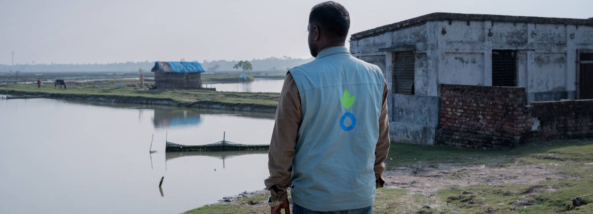 Ein Mitarbeiter von Aktion gegen den Hunger vor überflutetem Gebiet in Bangladesch