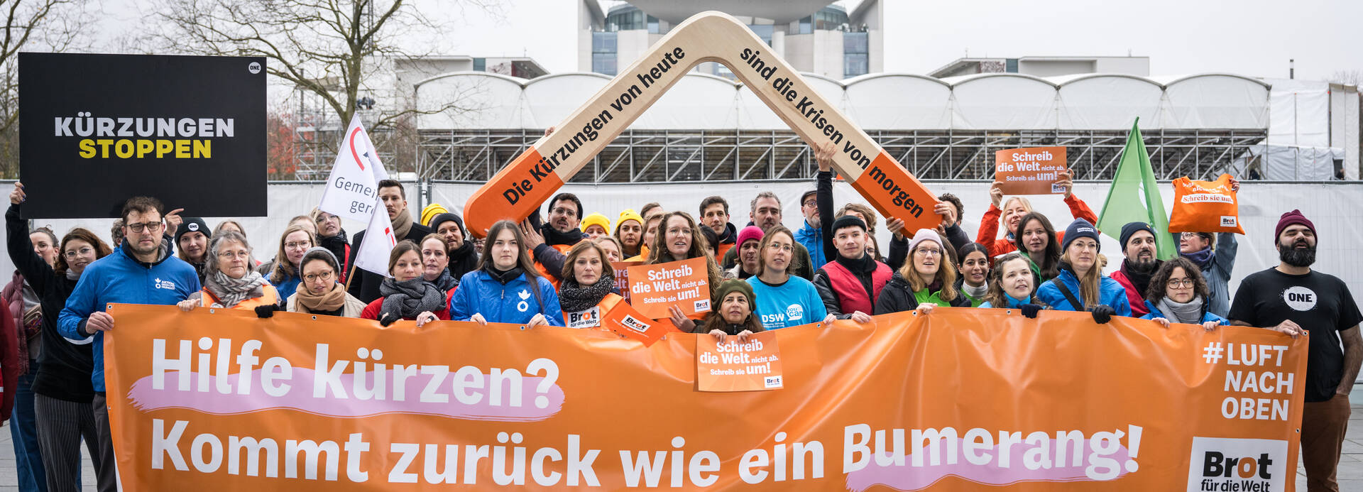 16 Hilfsorganisationen demonstrieren mit Riesenbumerang vor dem Paul-Löbe-Haus in Berlin und fordern Kurskorrektur für den Bundeshaushalt