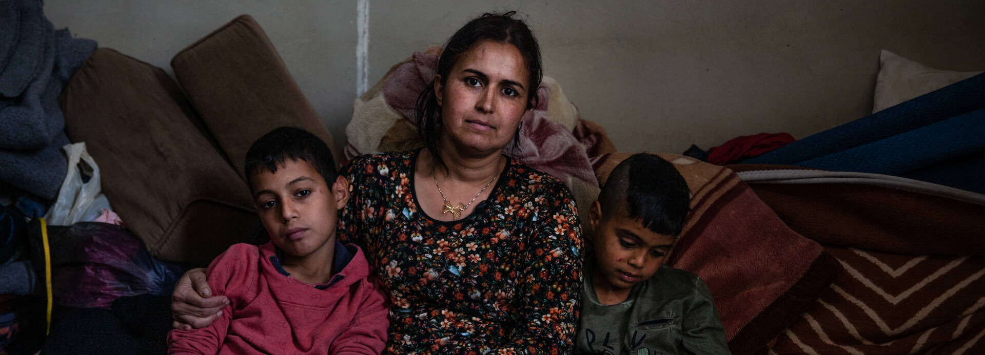 Die syrische Geflüchtete Rima Mohammed Mansour mit ihren Söhnen Ahmad (13, links) und Ali (7, rechts) in ihrem Zimmer der Gemeinschaftsunterkunft Rihaniyeh in Akkar, Nordlibanon, nahe der syrischen Grenze.