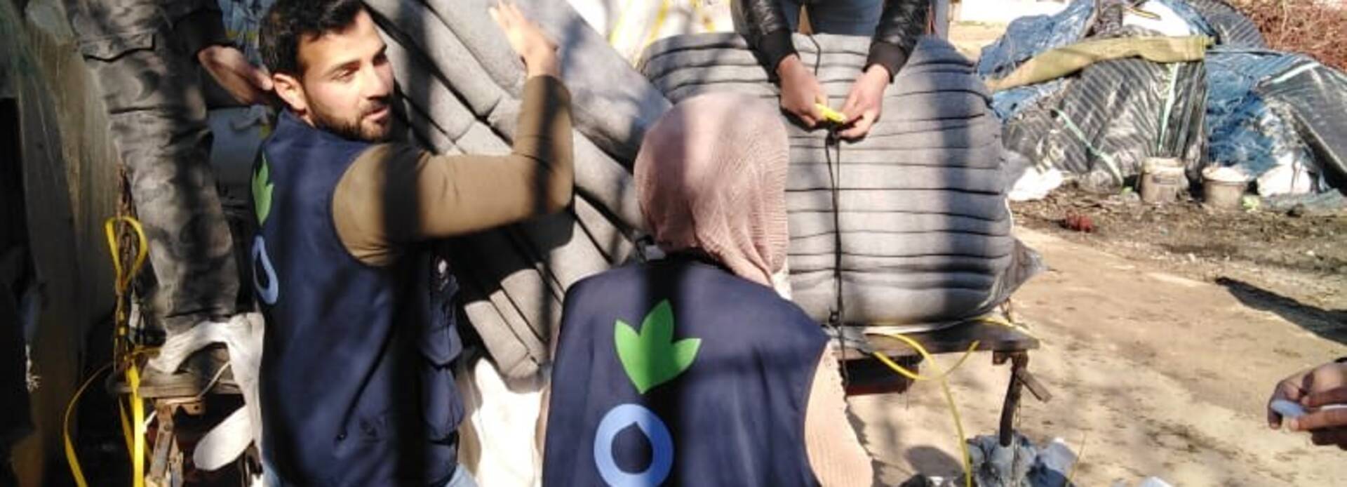 Helfer*innen tragen Hilfsgüter aus einem Lkw Helfer*innen tragen Hilfsgüter aus einem Lkw