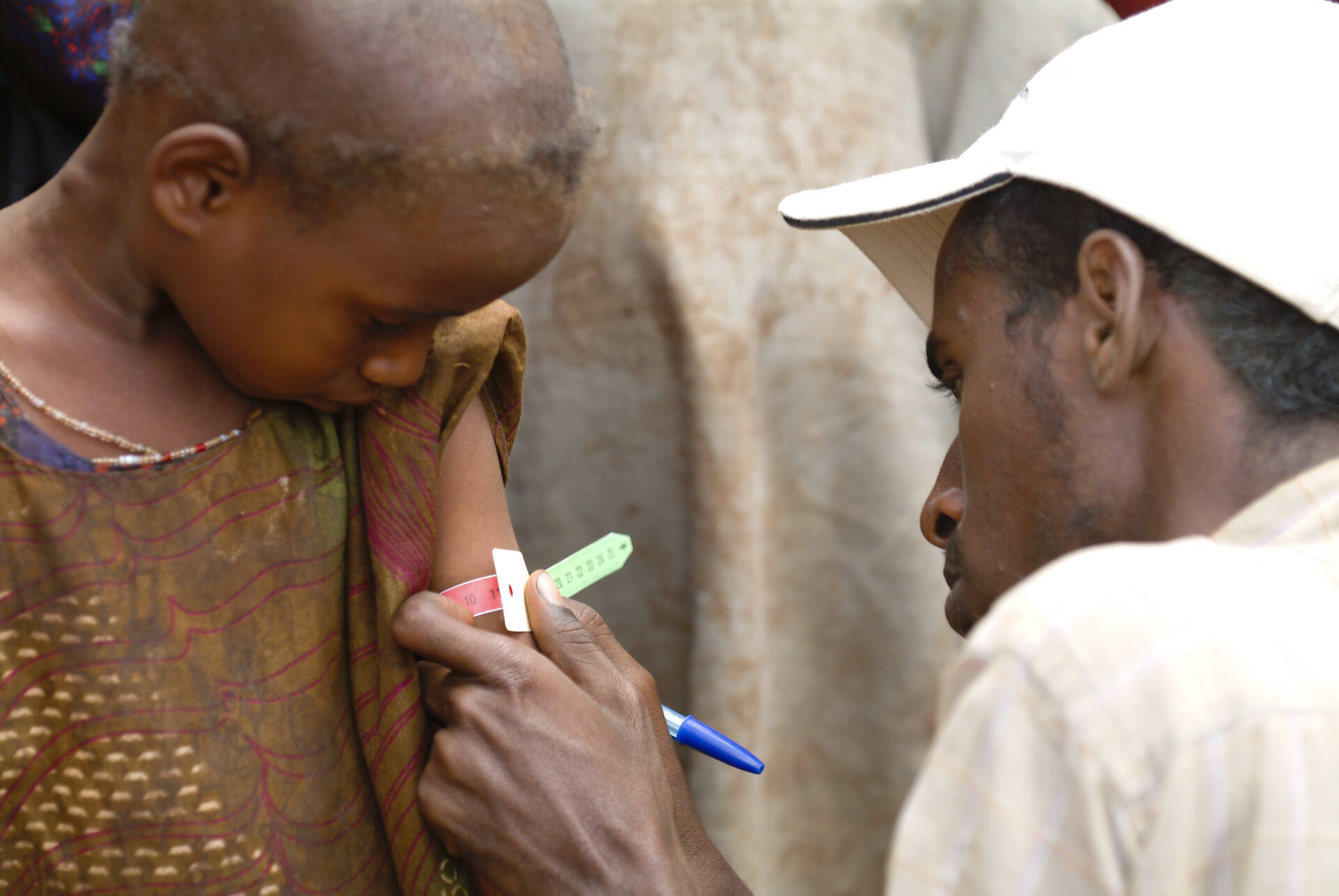 Helfer von Aktion gegen den Hunger untersucht einen Jungen auf Mangelernährung Helfer von Aktion gegen den Hunger untersucht einen Jungen auf Mangelernährung