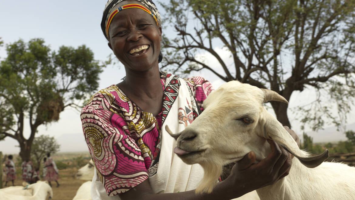 Fröhliche Frau mit ihrer Ziege