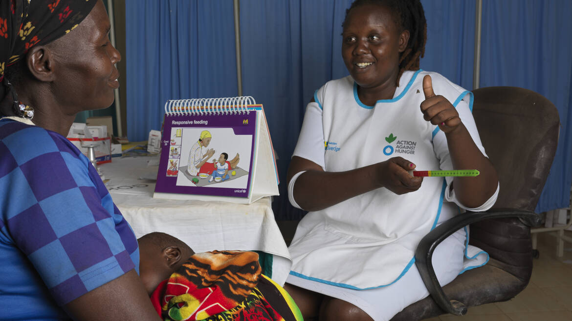 Mitarbeiterin von Aktion gegen den Hunger unterstützt Mutter und Kind