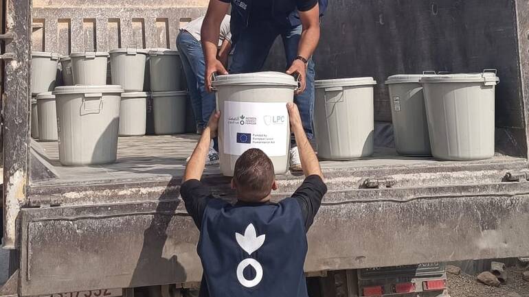 Zwei Mitarbeiter von Aktion gegen den Hunger laden Hygienekits von einem LKW