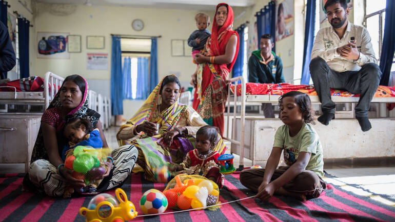 Familien sitzen und stehen rund um Spielzeug in der Klinik in Indien. Familien sitzen und stehen rund um Spielzeug in der Klinik in Indien.