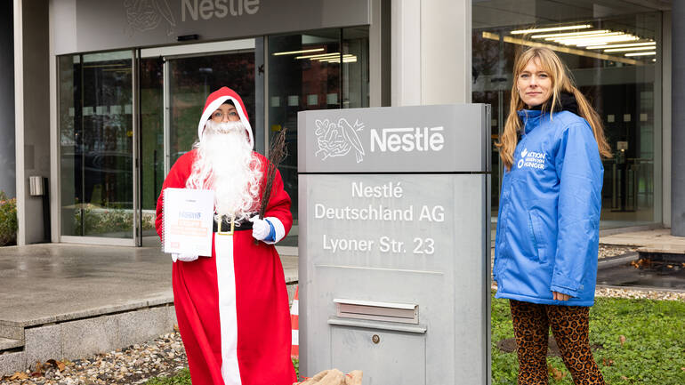 Der Nikolaus mit Rute und Unterschriften und eine Campaignerin am Briefkasten der Nestlé-Konzernzentrale in Frankfurt am Main. Der Nikolaus mit Rute und Unterschriften und eine Campaignerin am Briefkasten der Nestlé-Konzernzentrale in Frankfurt am Main.