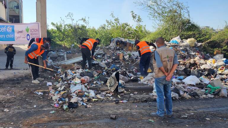 Helfende und Mitarbeitende von Aktion gegen den Hunger packen mit an beim Säubern der Umgebung von Müll.