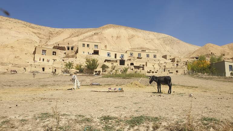 Ein Bergdorf in Afghanistan mit Esel im Vordergrund