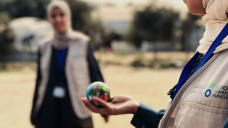 Eine Mitarbeiterin von Aktion gegen den Hunger hält einen kleinen Ball in der Hand.