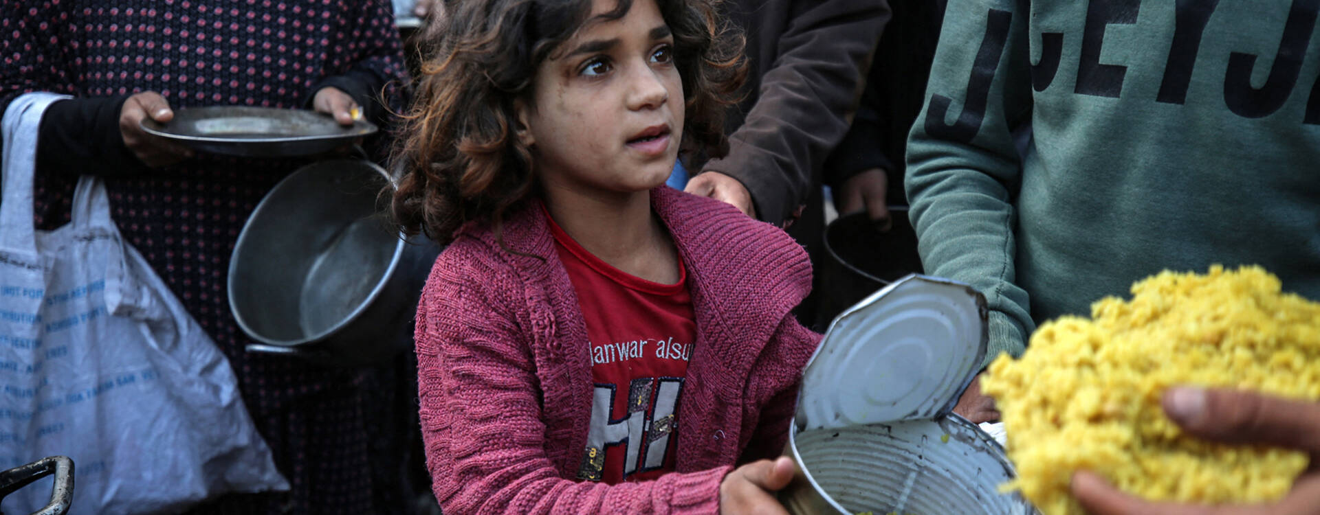 6 Monate Krieg in Gaza: Kinder müssen Schreckliches erleben Ein Mädchen im Gazastreifen hält eine geöffnete Dose mit Nahrung in der Hand.