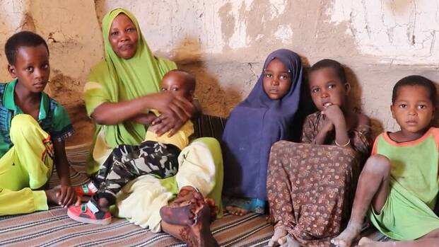 In Somalia sitzt eine Frau zusammen mit ihren Kindern in ihrem Haus. In Somalia sitzt eine Frau zusammen mit ihren Kindern in ihrem Haus.