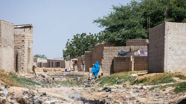 Frau läuft in Nigeria auf Schutt. Frau läuft in Nigeria auf Schutt.