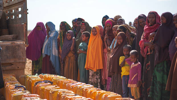 Sauberes Wasser aus Wassertank für Menschen in Somalia Menschen in Somalia warten mit ihren Kanistern auf sauberes Wasser aus Wassertank.