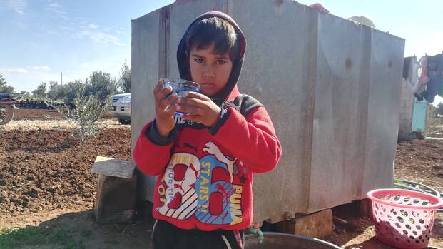 Khaled hält ein Wasserglas Khaled hält ein Wasserglas