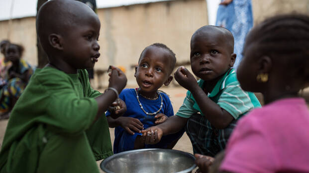 Kinder essen aus einer Schüssel Kinder essen aus einer Schüssel