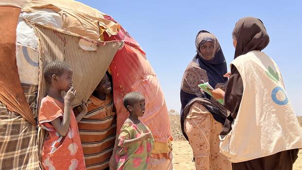 Mitarbeitende von Aktion gegen den Hunger sprechen mit einer Mutter und ihren Kindern vor ihrem Zelt in Somalia. Mitarbeitende von Aktion gegen den Hunger sprechen mit einer Mutter und ihren Kindern vor ihrem Zelt in Somalia.