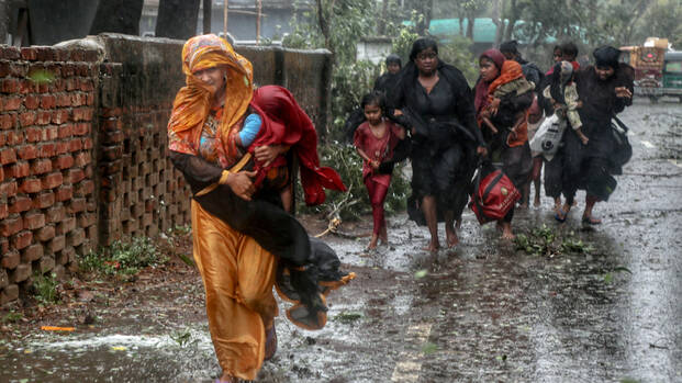 Frauen mit Kindern flüchten durch den Regen vor Zyklon Mocha in Bangladesch Frauen mit Kindern flüchten durch den Regen vor Zyklon Mocha in Bangladesch