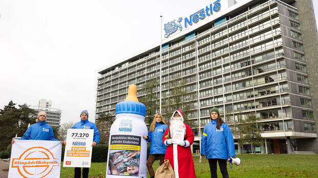 Das Team von Aktion gegen den Hunger und der Nikolaus stehen zusammen mit einer aufblasbaren Babymilchflasche vor der Nestlé-Zentrale in Frankfurt am Main. Das Team von Aktion gegen den Hunger und der Nikolaus stehen zusammen mit einer aufblasbaren Babymilchflasche vor der Nestlé-Zentrale in Frankfurt am Main.