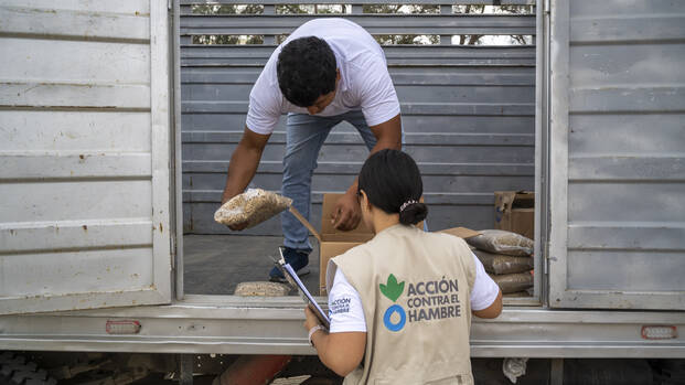 Zwei unserer Mitarbeitenden in Peru entladen einen Lastwagen mit Hilfsgütern Zwei unserer Mitarbeitenden in Peru entladen einen Lastwagen mit Hilfsgütern