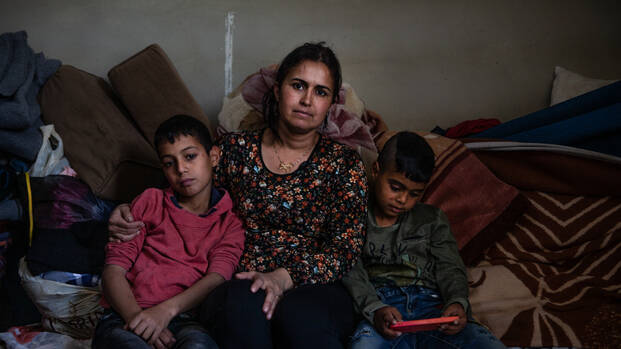 Die syrische Geflüchtete Rima Mohammed Mansour mit ihren Söhnen Ahmad (13, links) und Ali (7, rechts) in ihrem Zimmer der Gemeinschaftsunterkunft Rihaniyeh in Akkar, Nordlibanon, nahe der syrischen Grenze.