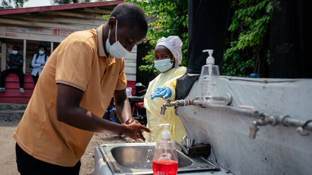 Menschen in der Demokratischen Republik Kongo mit Masken waschen sich die Hände nach Ausbruch des Ebola-Virus.