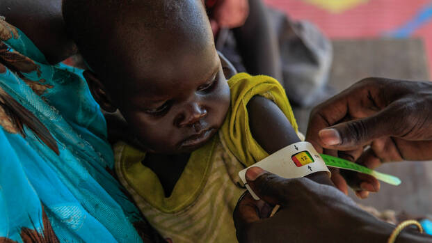 Helfer untersuchen im Südsudan ein Kind. Helfer untersuchen im Südsudan ein Kind.